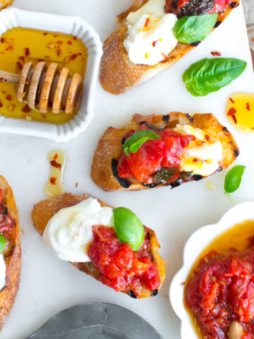 Tomato Confit & Burrata Crostini with a spicy sweet drizzle of chili honey