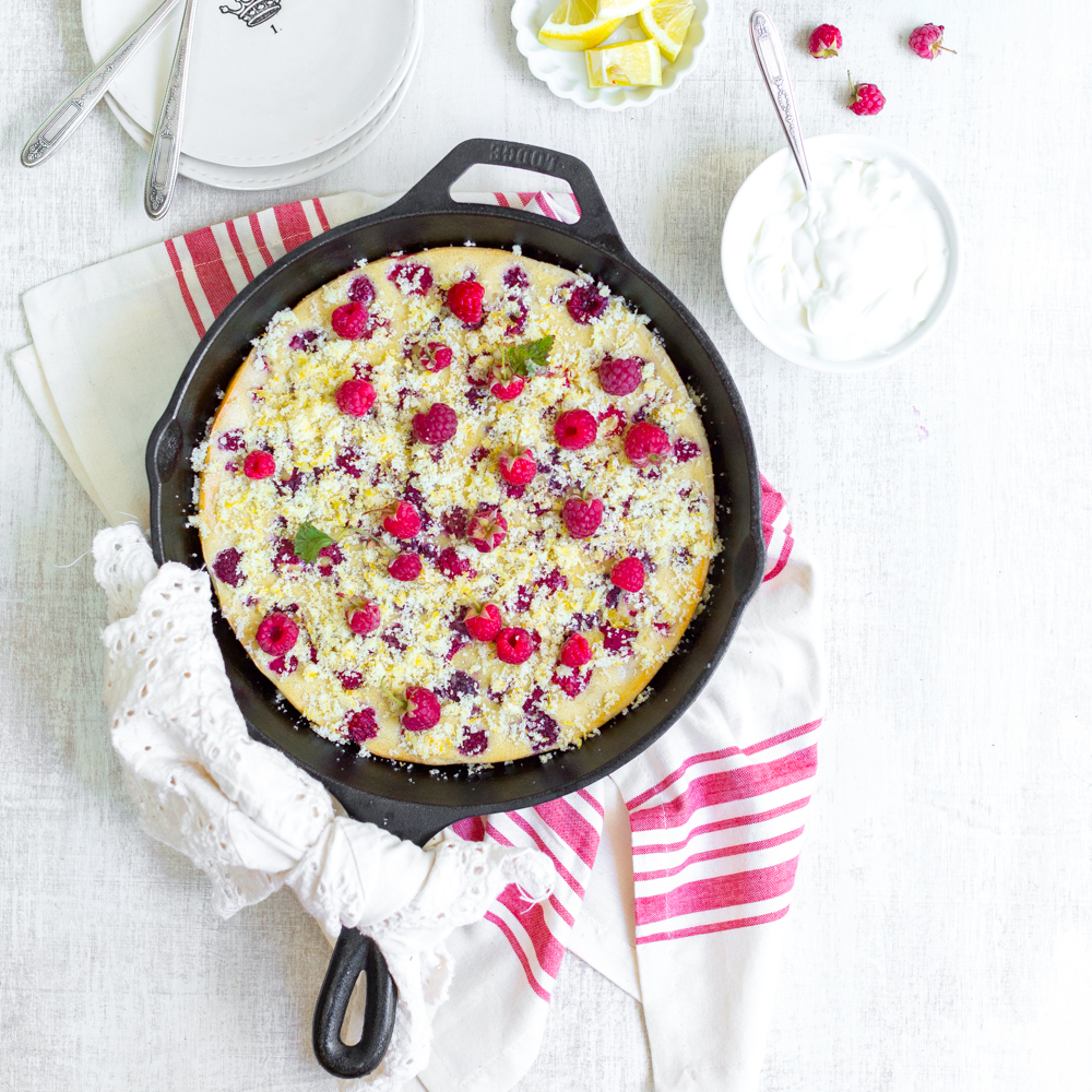 Raspberry Buttermilk Clafoutis topped with fresh raspberries and lemon sugar served with rich crème fraîche.