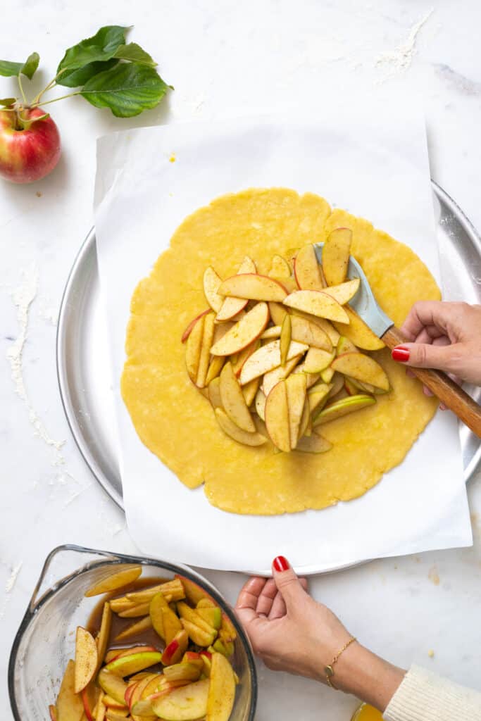 Filling apple cheddar pie dough with apples